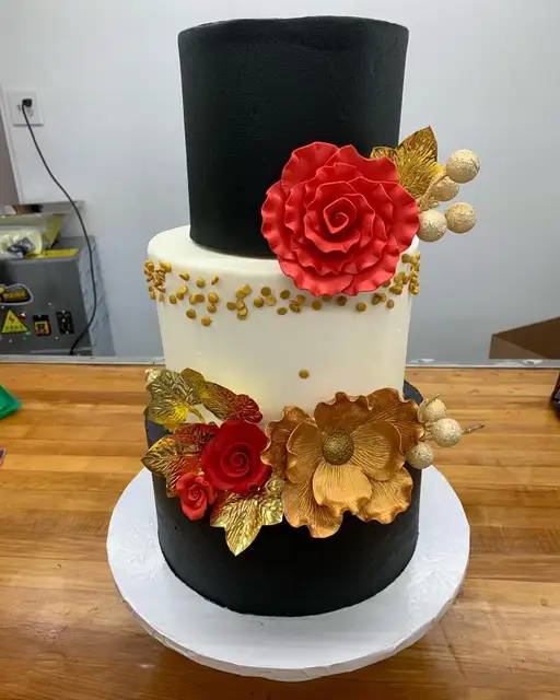 Black and white tiered cake with red flowers